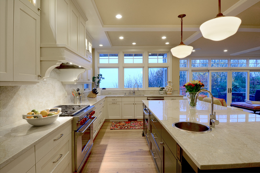 Klassische Küche in L-Form mit Schrankfronten im Shaker-Stil, weißen Schränken, Küchenrückwand in Weiß, Küchengeräten aus Edelstahl, braunem Holzboden und Kücheninsel in Seattle
