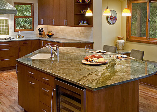 Large trendy medium tone wood floor eat-in kitchen photo in Seattle with an undermount sink, flat-panel cabinets, medium tone wood cabinets, granite countertops, white backsplash, ceramic backsplash, stainless steel appliances, an island and green countertops