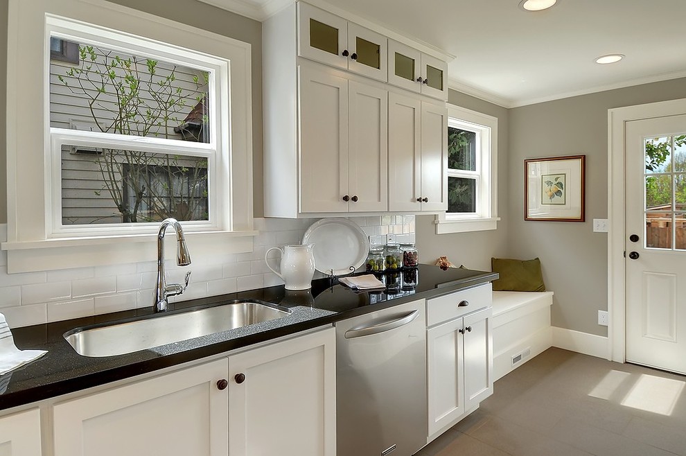 Design ideas for a classic enclosed kitchen in Seattle with a submerged sink, shaker cabinets, white cabinets, white splashback, metro tiled splashback and stainless steel appliances.