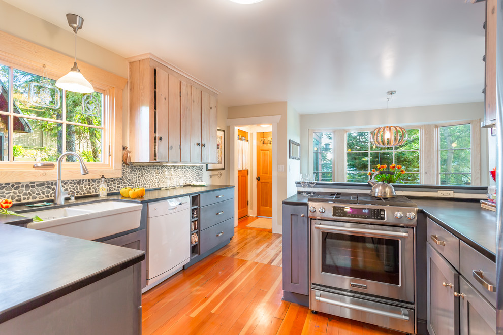 Foto de cocina marinera con fregadero sobremueble, armarios estilo shaker, puertas de armario azules, salpicadero verde, salpicadero de azulejos de piedra y electrodomésticos de acero inoxidable