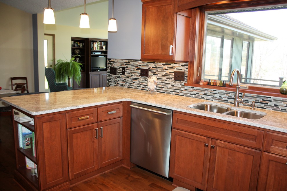 Exempel på ett mellanstort klassiskt kök, med en undermonterad diskho, luckor med upphöjd panel, skåp i mellenmörkt trä, bänkskiva i kvarts, flerfärgad stänkskydd, glaspanel som stänkskydd, rostfria vitvaror, mörkt trägolv, en halv köksö och brunt golv