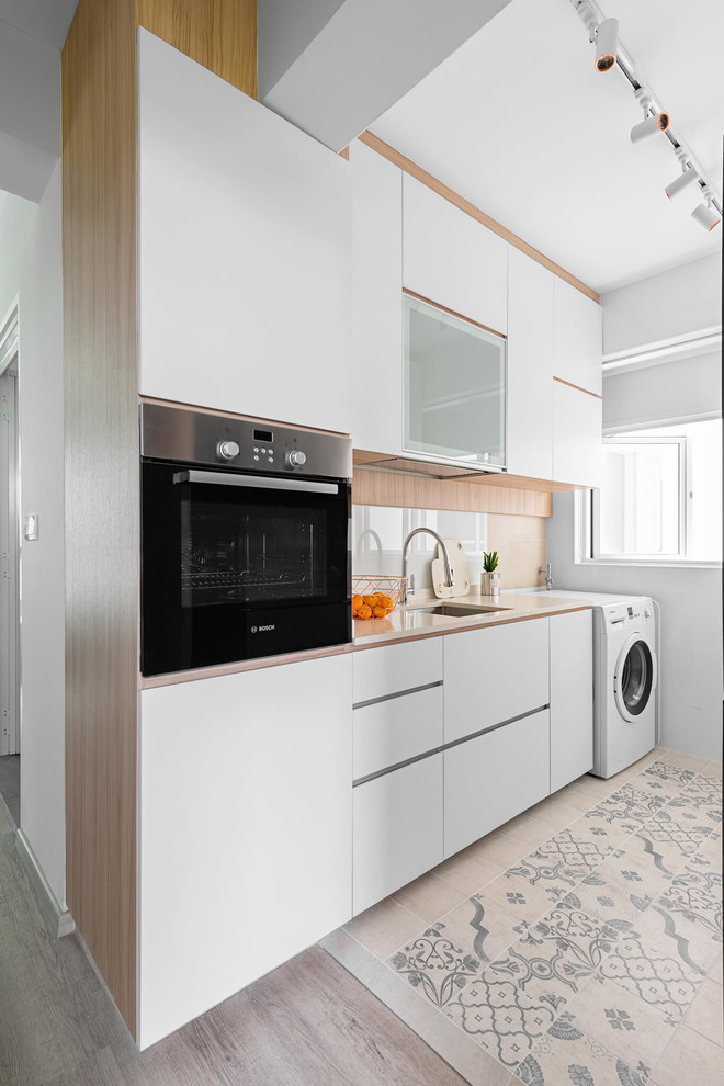Modelo de cocina actual con fregadero bajoencimera, armarios con paneles lisos, puertas de armario blancas, suelo beige y encimeras beige