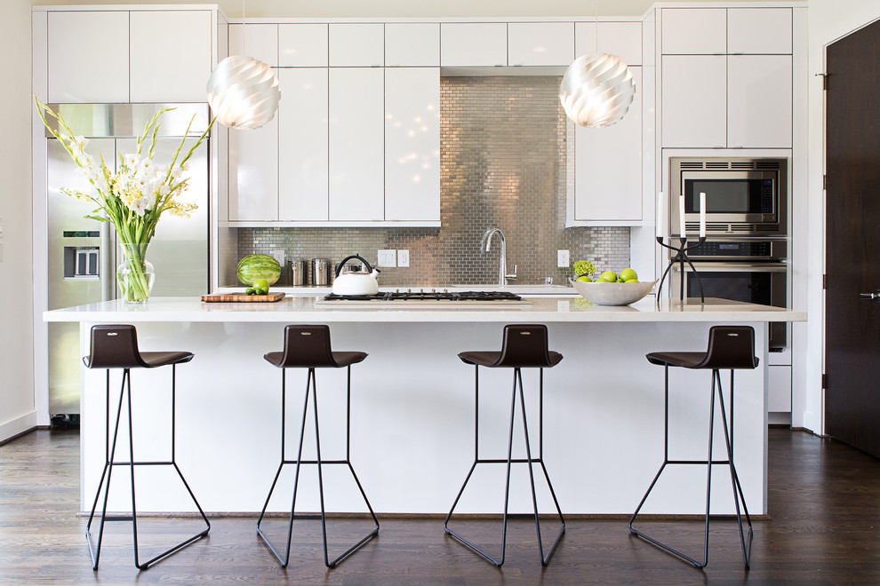 Trendy dark wood floor kitchen photo in Houston with flat-panel cabinets, white cabinets, metallic backsplash, mosaic tile backsplash, stainless steel appliances and an island