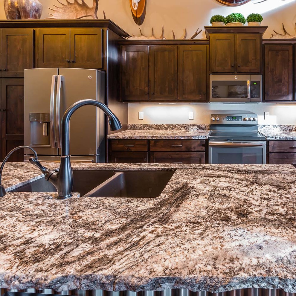 Esempio di una cucina rustica di medie dimensioni con lavello sottopiano, ante in stile shaker, ante in legno bruno, top in granito, elettrodomestici in acciaio inossidabile, parquet chiaro e pavimento beige
