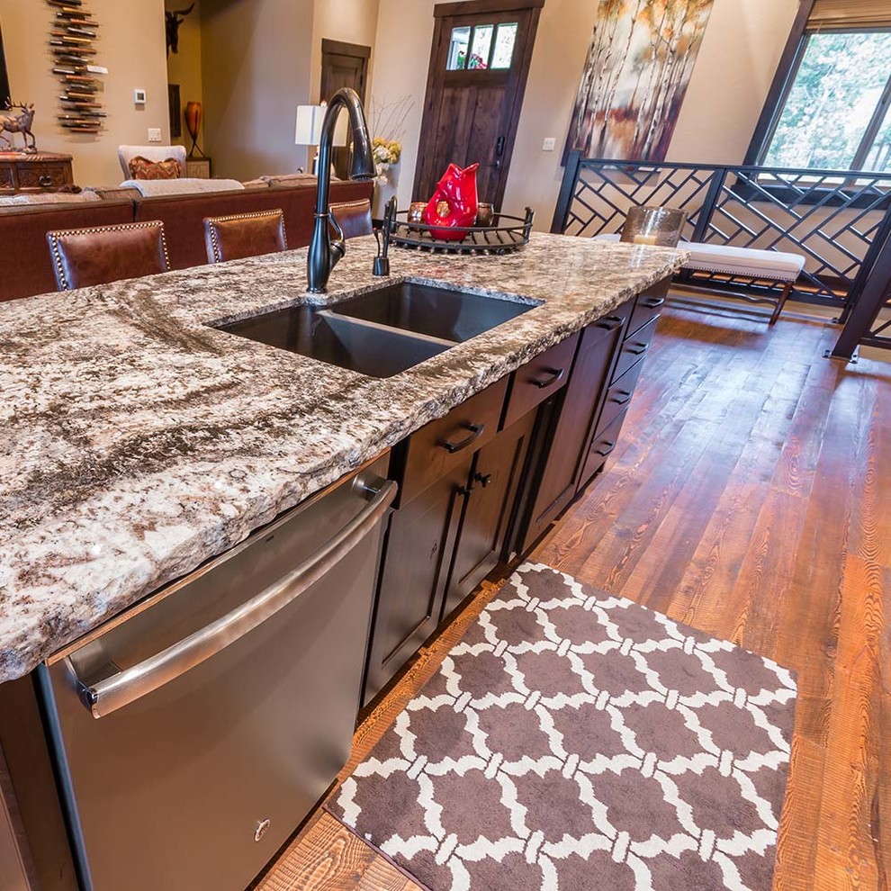 This is an example of a medium sized rustic single-wall open plan kitchen in Other with a submerged sink, shaker cabinets, dark wood cabinets, granite worktops, stainless steel appliances, light hardwood flooring, an island and beige floors.
