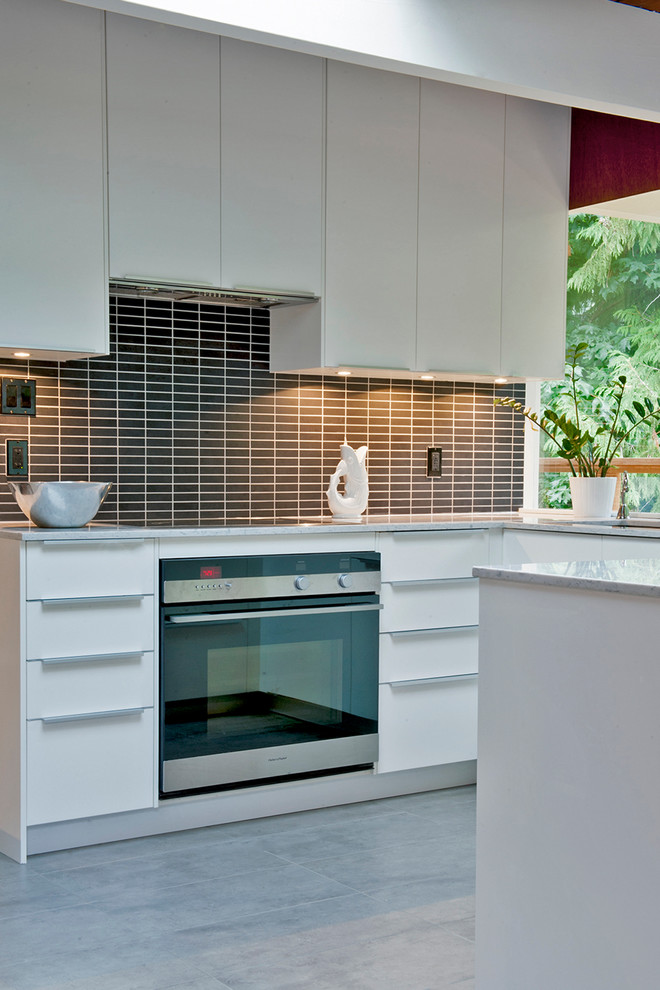 Inspiration for a mid-sized 1960s u-shaped ceramic tile eat-in kitchen remodel in Vancouver with a drop-in sink, flat-panel cabinets, white cabinets, quartz countertops, black backsplash, subway tile backsplash and stainless steel appliances