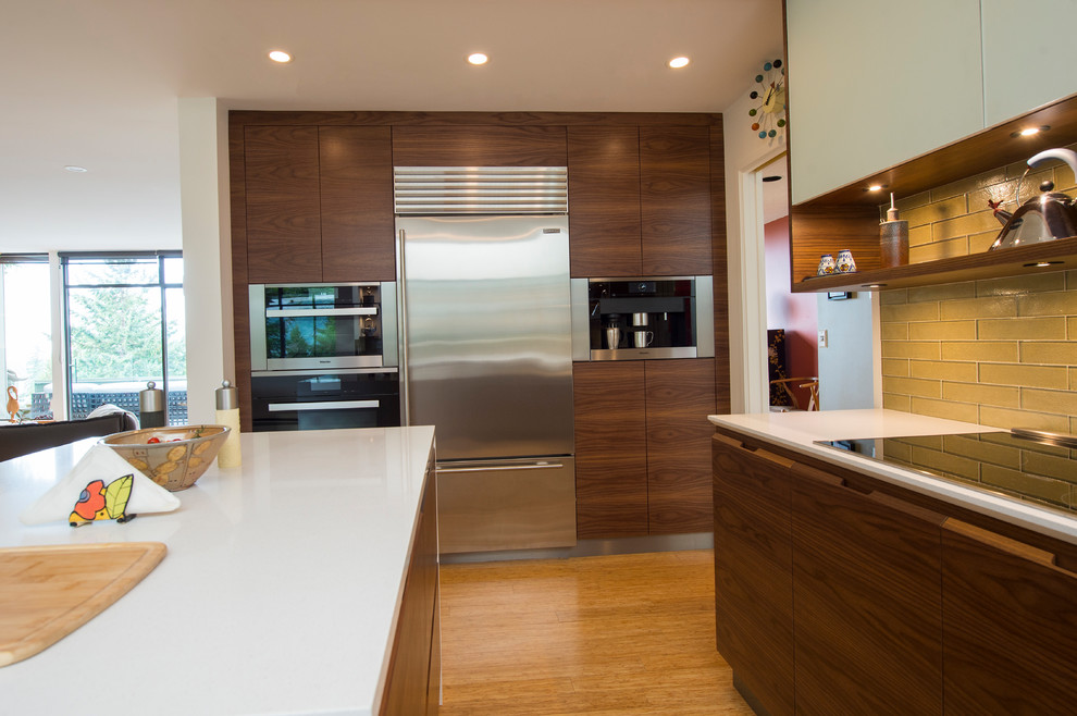 Example of a mid-sized minimalist u-shaped bamboo floor and beige floor eat-in kitchen design in Vancouver with an undermount sink, flat-panel cabinets, dark wood cabinets, quartz countertops, green backsplash, glass tile backsplash, stainless steel appliances and an island