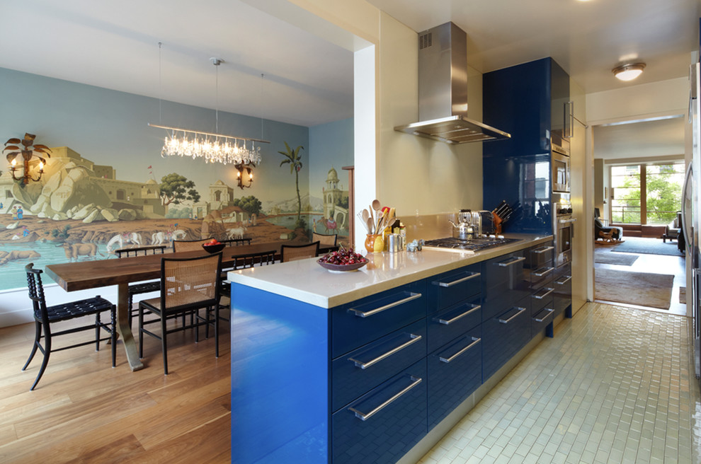Medium sized classic galley kitchen/diner in New York with flat-panel cabinets, blue cabinets, concrete worktops, coloured appliances, a breakfast bar, porcelain flooring and grey floors.