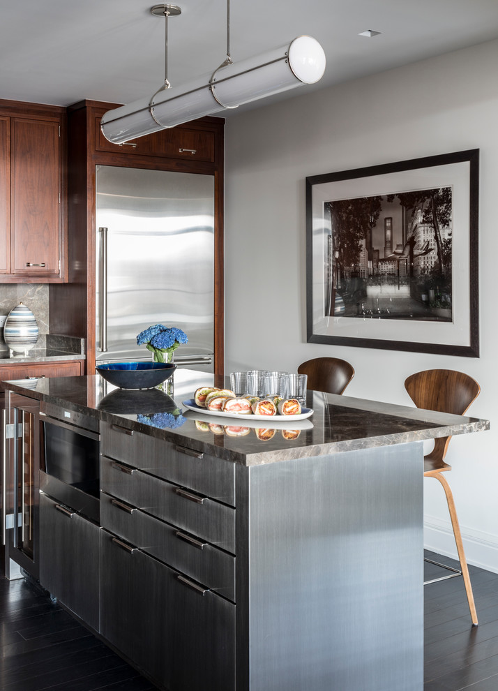 Imagen de cocina contemporánea con puertas de armario de madera en tonos medios, electrodomésticos de acero inoxidable, suelo de madera oscura y una isla