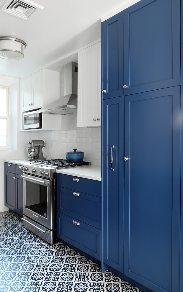 Design ideas for a medium sized classic galley kitchen/diner in New York with a submerged sink, shaker cabinets, blue cabinets, engineered stone countertops, white splashback, ceramic splashback, stainless steel appliances, ceramic flooring, no island and multi-coloured floors.