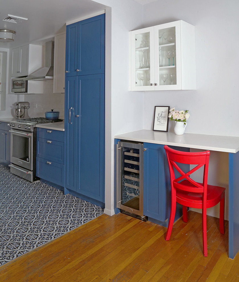 Example of a mid-sized classic galley ceramic tile and multicolored floor eat-in kitchen design in New York with an undermount sink, shaker cabinets, blue cabinets, quartz countertops, white backsplash, ceramic backsplash, stainless steel appliances and no island