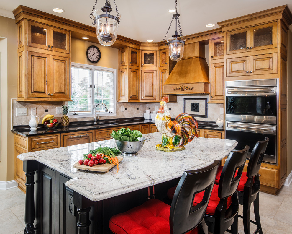 Example of a large classic l-shaped porcelain tile eat-in kitchen design in Philadelphia with an undermount sink, beaded inset cabinets, medium tone wood cabinets, granite countertops, beige backsplash, stone tile backsplash, stainless steel appliances and an island