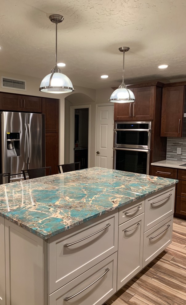 Example of a mid-sized transitional u-shaped porcelain tile and multicolored floor eat-in kitchen design in Phoenix with a drop-in sink, shaker cabinets, white cabinets, granite countertops, multicolored backsplash, glass tile backsplash, stainless steel appliances, turquoise countertops and an island