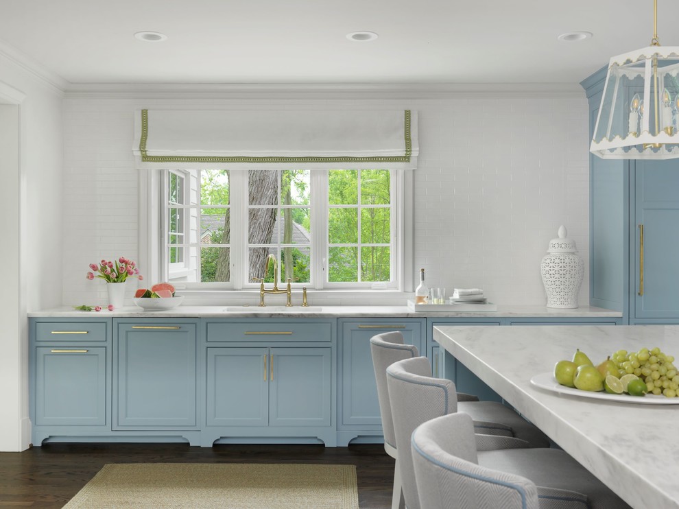 Imagen de cocina clásica con armarios estilo shaker, puertas de armario azules, encimera de mármol, salpicadero blanco, suelo de madera oscura, una isla y encimeras blancas