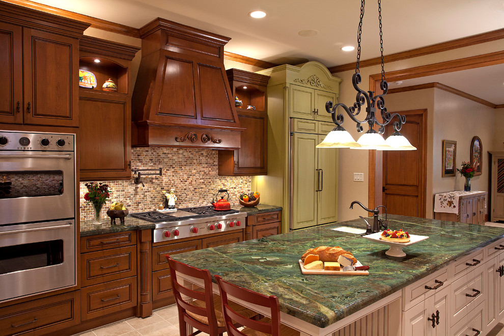 Eat-in kitchen - large traditional galley beige floor eat-in kitchen idea in Houston with an undermount sink, raised-panel cabinets, granite countertops, stainless steel appliances, brown cabinets, beige backsplash and an island