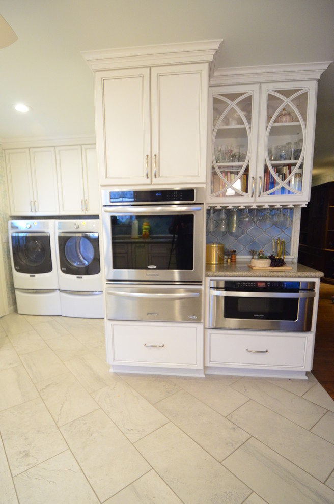 Photo of a medium sized classic l-shaped kitchen in Houston with a submerged sink, recessed-panel cabinets, white cabinets, engineered stone countertops, blue splashback, mosaic tiled splashback, stainless steel appliances, porcelain flooring and a breakfast bar.