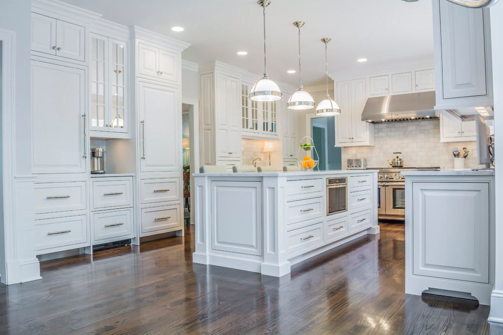 Inspiration for a large classic u-shaped kitchen in New York with raised-panel cabinets, white cabinets, marble worktops, dark hardwood flooring and an island.