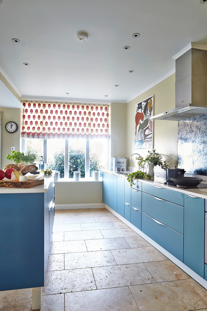 Design ideas for a large modern galley kitchen/diner in Hampshire with a double-bowl sink, flat-panel cabinets, blue cabinets, composite countertops, white splashback, marble splashback, stainless steel appliances, slate flooring, an island and white floors.