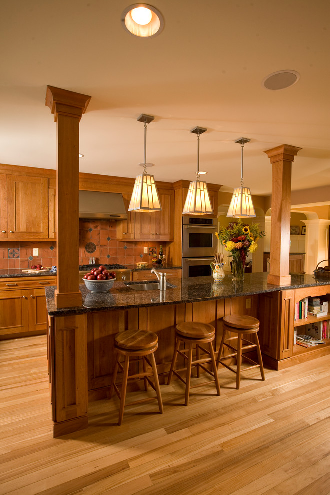 Diseño de cocina de estilo americano grande con armarios estilo shaker, salpicadero marrón, electrodomésticos de acero inoxidable y suelo de madera clara