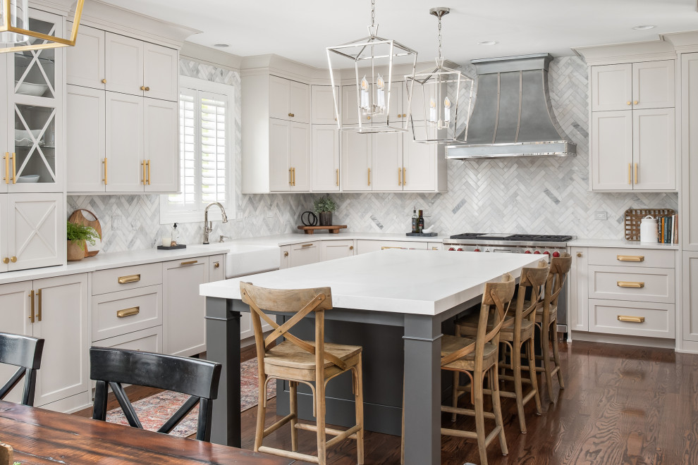 This is an example of a large classic u-shaped kitchen/diner in Chicago with a belfast sink, grey cabinets, engineered stone countertops, grey splashback, marble splashback, stainless steel appliances, dark hardwood flooring, an island, brown floors, white worktops and shaker cabinets.