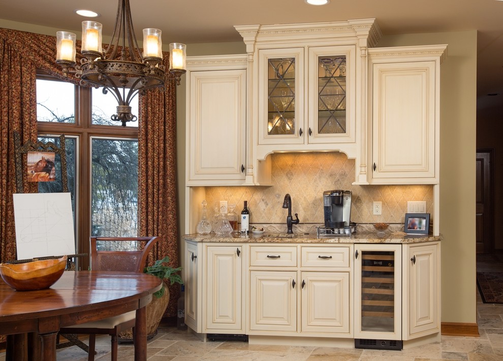 This is an example of a large traditional u-shaped kitchen/diner in Columbus with a submerged sink, beaded cabinets, beige cabinets, granite worktops, beige splashback, stone tiled splashback, stainless steel appliances and an island.