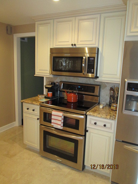Exempel på ett klassiskt kök, med luckor med glaspanel, vita skåp, granitbänkskiva, beige stänkskydd, stänkskydd i stenkakel och rostfria vitvaror