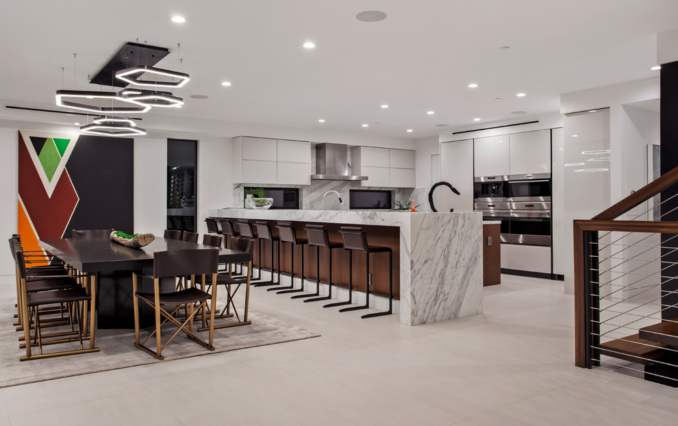 Example of a large trendy u-shaped gray floor open concept kitchen design in Los Angeles with flat-panel cabinets, white cabinets, marble countertops, white backsplash, marble backsplash, stainless steel appliances, an island and white countertops