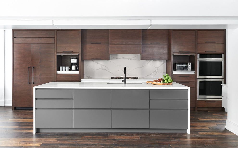 Photo of an expansive contemporary galley open plan kitchen in Toronto with a submerged sink, flat-panel cabinets, dark wood cabinets, engineered stone countertops, white splashback, stone slab splashback, integrated appliances, dark hardwood flooring, an island and white worktops.