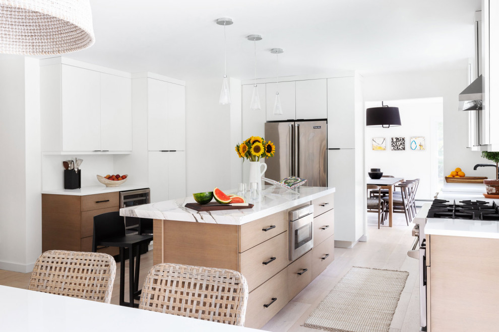 Moderne Küche in U-Form mit flächenbündigen Schrankfronten, weißen Schränken, Küchengeräten aus Edelstahl, hellem Holzboden, Kücheninsel, beigem Boden und weißer Arbeitsplatte in New York