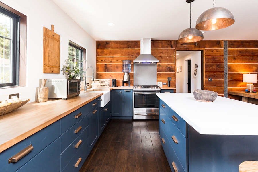 This is an example of a small scandi l-shaped open plan kitchen in Other with a belfast sink, shaker cabinets, blue cabinets, wood worktops, stainless steel appliances, dark hardwood flooring and an island.