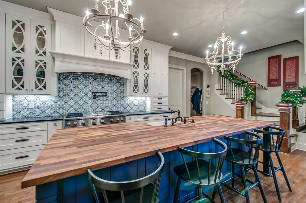Klassische Küche mit Landhausspüle, Schrankfronten im Shaker-Stil, blauen Schränken, Küchenrückwand in Blau, Küchengeräten aus Edelstahl, hellem Holzboden und Kücheninsel in Nashville