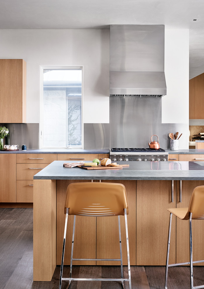 Foto di una cucina minimal con ante lisce, ante in legno scuro, paraspruzzi a effetto metallico, elettrodomestici in acciaio inossidabile e parquet scuro