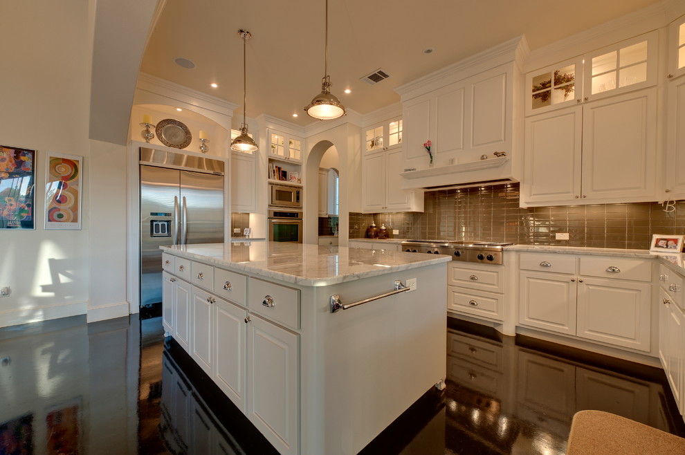 Klassisk inredning av ett avskilt, stort u-kök, med luckor med upphöjd panel, vita skåp, marmorbänkskiva, beige stänkskydd, stänkskydd i glaskakel, rostfria vitvaror, linoleumgolv, en köksö och svart golv