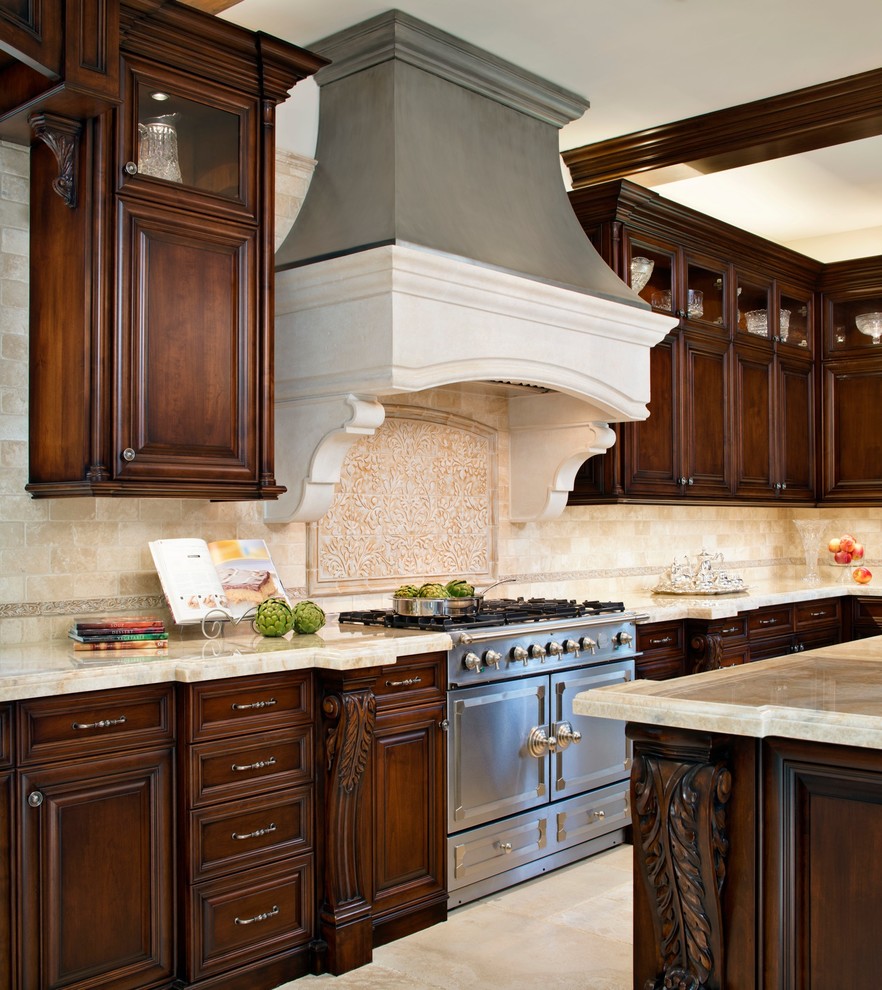 Example of a classic u-shaped eat-in kitchen design in Los Angeles with a farmhouse sink, dark wood cabinets, onyx countertops, beige backsplash, stone tile backsplash and stainless steel appliances