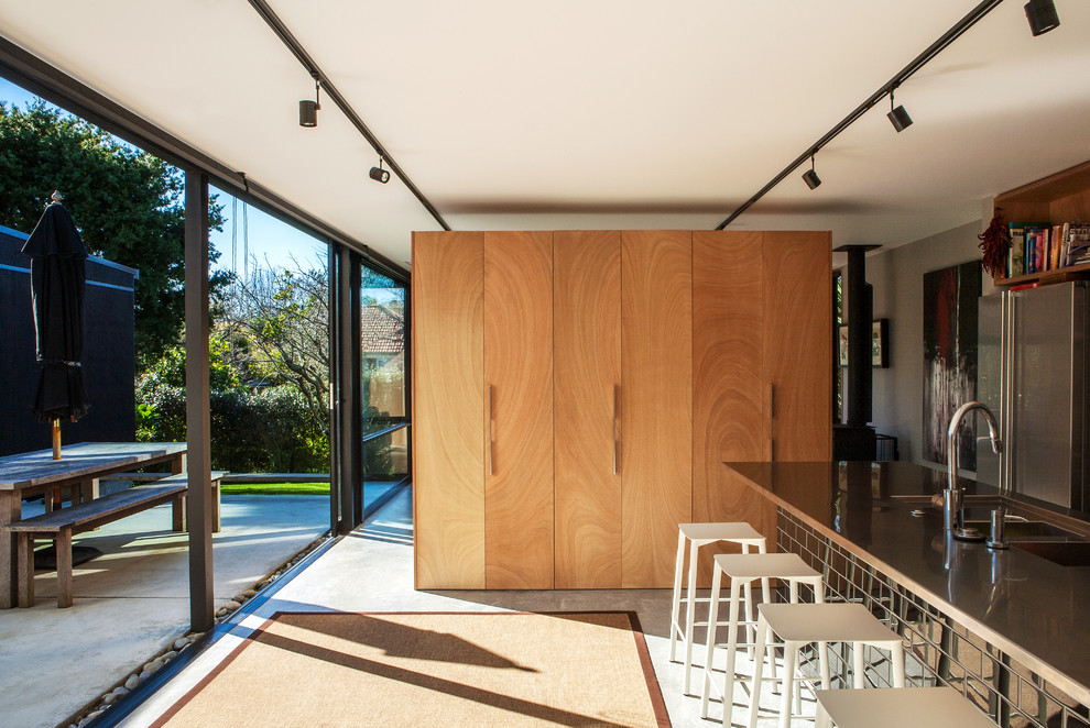 Идея дизайна: угловая кухня-гостиная в современном стиле с бетонным полом и островом