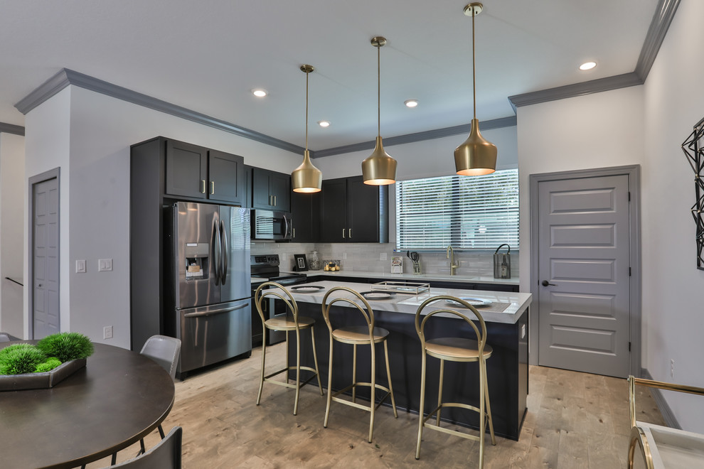 Medium sized modern galley open plan kitchen in Tampa with a submerged sink, shaker cabinets, black cabinets, stainless steel appliances and an island.
