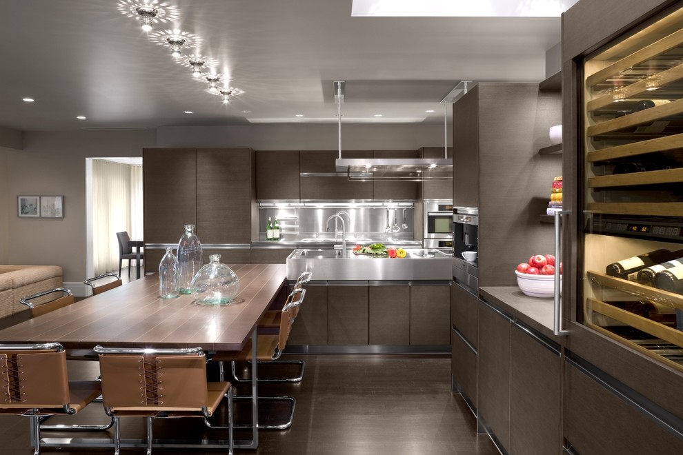 Moderne Wohnküche mit Küchengeräten aus Edelstahl, integriertem Waschbecken, flächenbündigen Schrankfronten, hellbraunen Holzschränken, Edelstahl-Arbeitsplatte und Küchenrückwand in Metallic in Boston