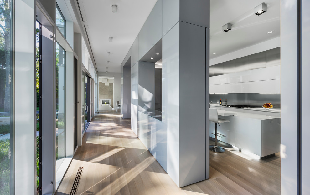 Стильный дизайн: большая параллельная кухня-гостиная в стиле модернизм с одинарной мойкой, плоскими фасадами, серыми фасадами, серым фартуком, техникой под мебельный фасад и светлым паркетным полом - последний тренд