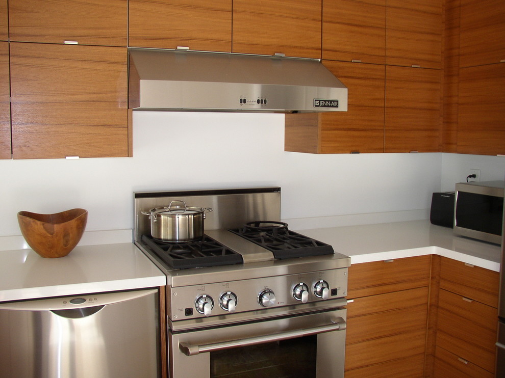 Bild på ett litet funkis kök, med en undermonterad diskho, släta luckor, skåp i mellenmörkt trä, bänkskiva i kvartsit, vitt stänkskydd, stänkskydd i sten och rostfria vitvaror