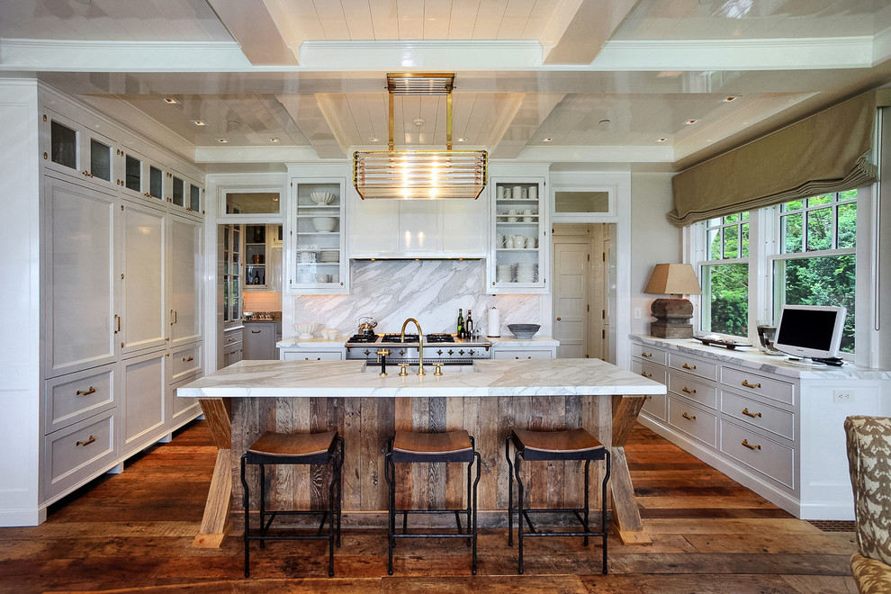 Klassische Küche in U-Form mit Glasfronten, weißen Schränken, bunter Rückwand, Küchengeräten aus Edelstahl, braunem Holzboden und Kücheninsel in New York