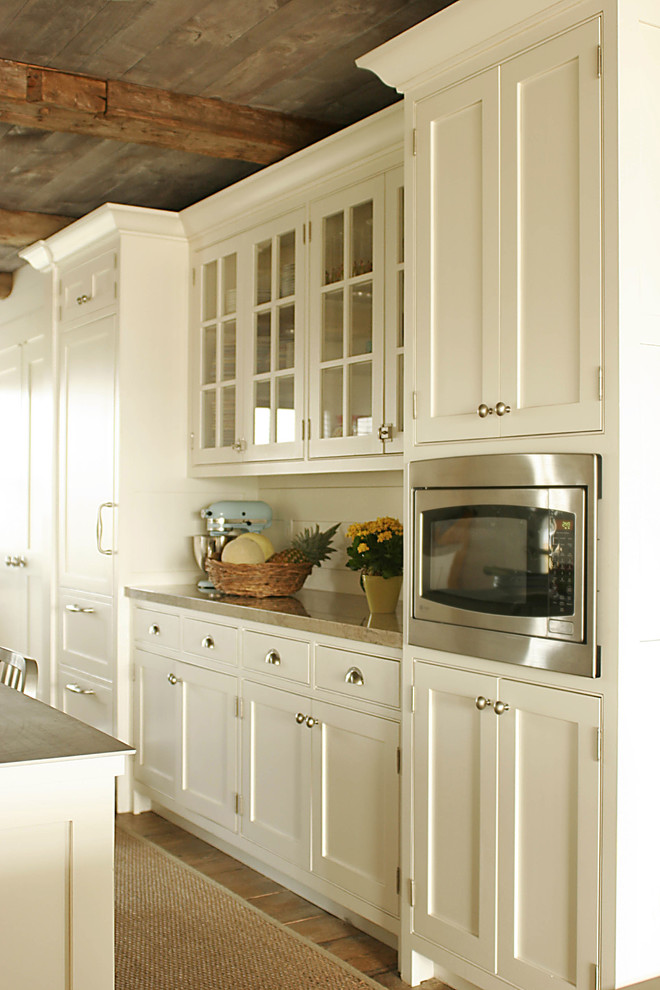 Inspiration för stora lantliga kök, med en enkel diskho, luckor med infälld panel, vita skåp, integrerade vitvaror och mellanmörkt trägolv