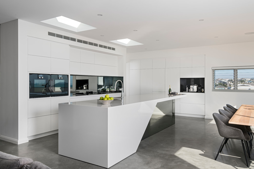 Foto de cocina moderna grande abierta con encimera de acrílico, salpicadero con efecto espejo, suelo de cemento y suelo gris