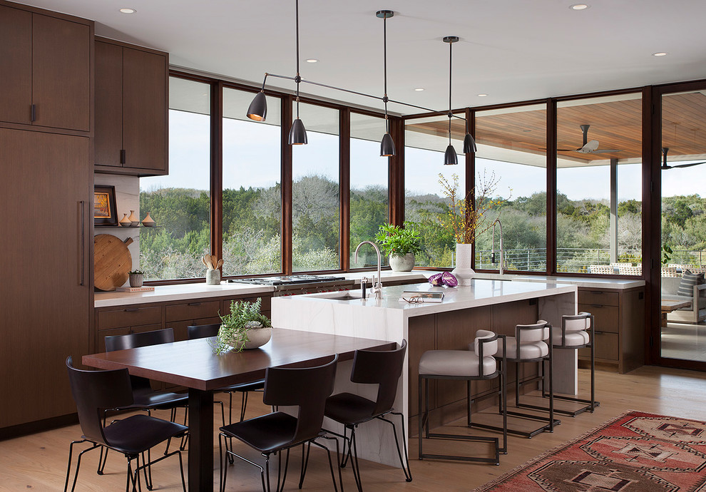 Inspiration for a contemporary l-shaped kitchen in Austin with flat-panel cabinets, dark wood cabinets, stainless steel appliances, light hardwood flooring, an island, beige floors and white worktops.