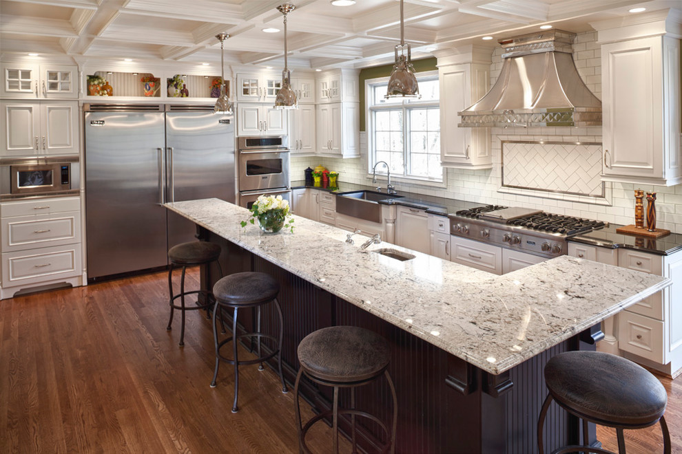Eat-in kitchen - transitional l-shaped eat-in kitchen idea in Cincinnati with a farmhouse sink, raised-panel cabinets, white cabinets, white backsplash, subway tile backsplash and stainless steel appliances