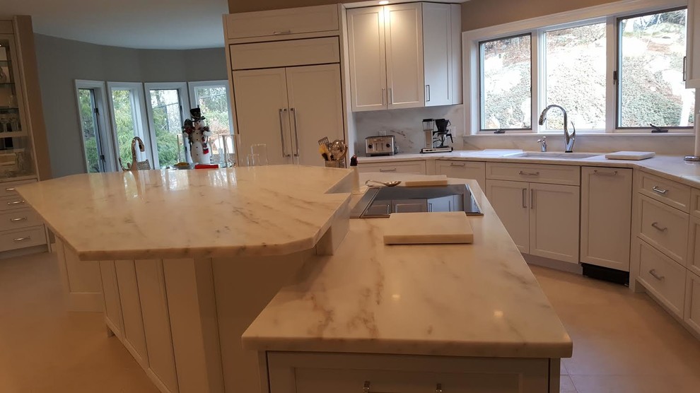 Photo of a large classic l-shaped open plan kitchen in San Diego with a submerged sink, shaker cabinets, white cabinets, marble worktops, white splashback, marble splashback, stainless steel appliances, an island, beige floors and grey worktops.