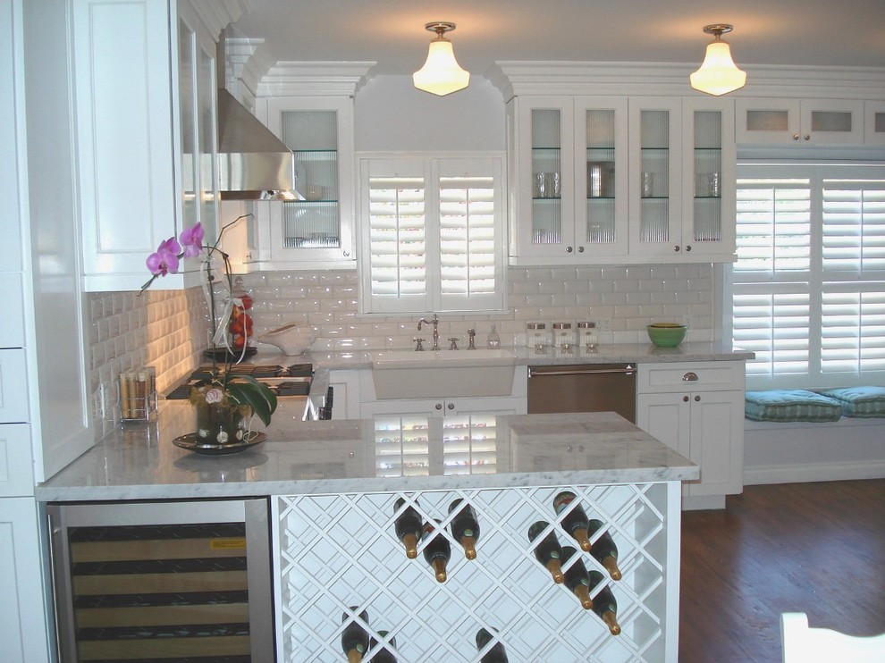 Eat-in kitchen - mid-sized traditional u-shaped dark wood floor eat-in kitchen idea in Los Angeles with a farmhouse sink, shaker cabinets, white cabinets, granite countertops, white backsplash, subway tile backsplash, stainless steel appliances and an island