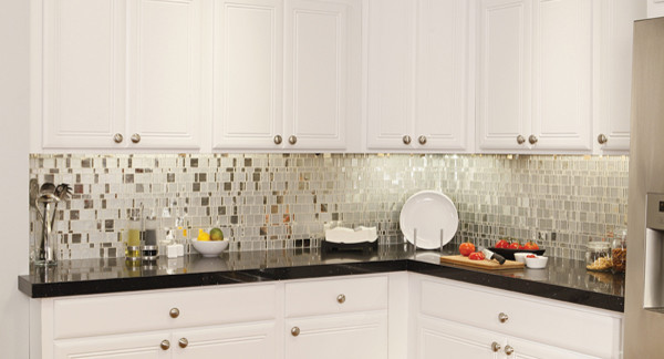 Modelo de cocina ecléctica con armarios con paneles con relieve, puertas de armario blancas, encimera de esteatita, salpicadero metalizado, salpicadero con efecto espejo y encimeras blancas