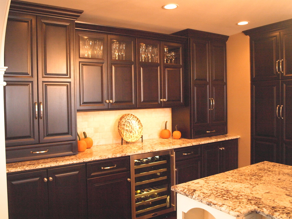 Exempel på ett stort klassiskt kök, med en rustik diskho, luckor med upphöjd panel, skåp i mörkt trä, granitbänkskiva, beige stänkskydd, stänkskydd i travertin, rostfria vitvaror, mörkt trägolv, en köksö och brunt golv
