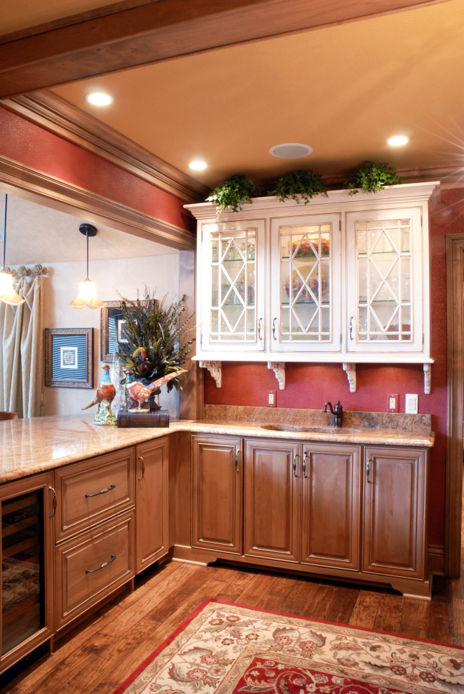 Inspiration för mellanstora klassiska flerfärgat kök, med en undermonterad diskho, luckor med upphöjd panel, skåp i ljust trä, granitbänkskiva, beige stänkskydd, stänkskydd i stenkakel, integrerade vitvaror, mellanmörkt trägolv, en köksö och brunt golv