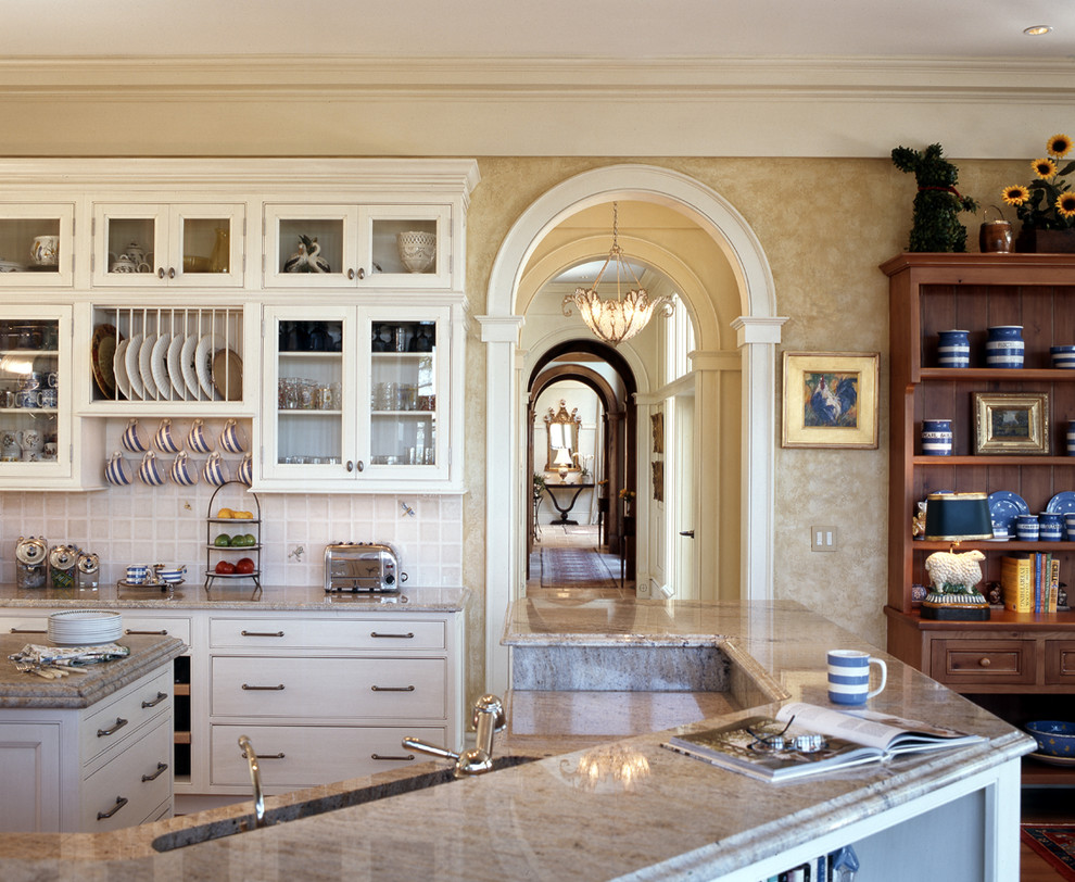 Diseño de cocinas en U tradicional, grande, abierto, con armarios con rebordes decorativos, fregadero bajoencimera, puertas de armario blancas, salpicadero blanco, encimera de mármol, salpicadero de azulejos de cerámica, suelo de madera clara y una isla